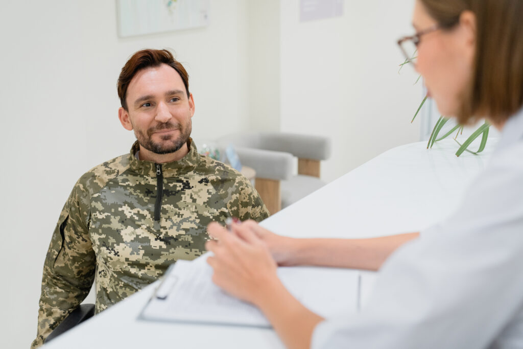 Clinician reviewing paperwork with a patient in a military uniform